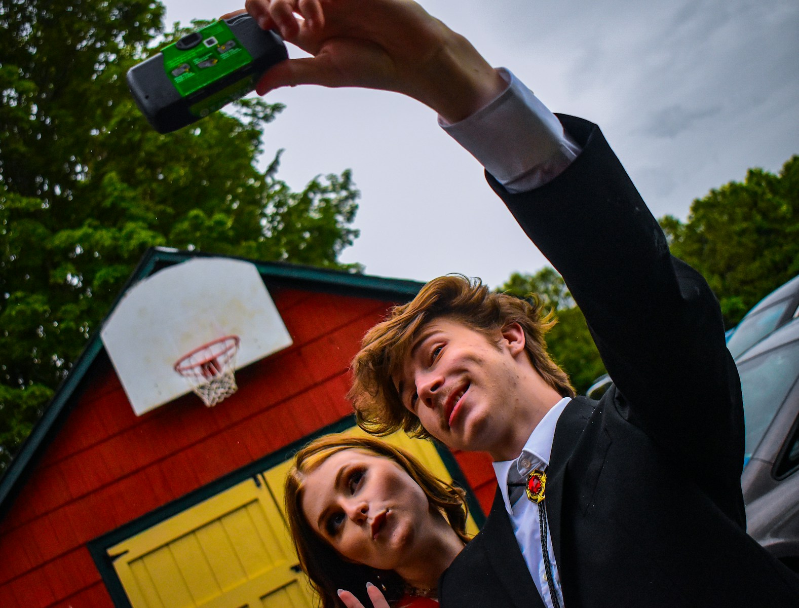 man in black suit jacket holding smartphone